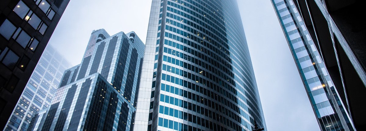 A close-up view of several large, modern steel and glass skyscrapers