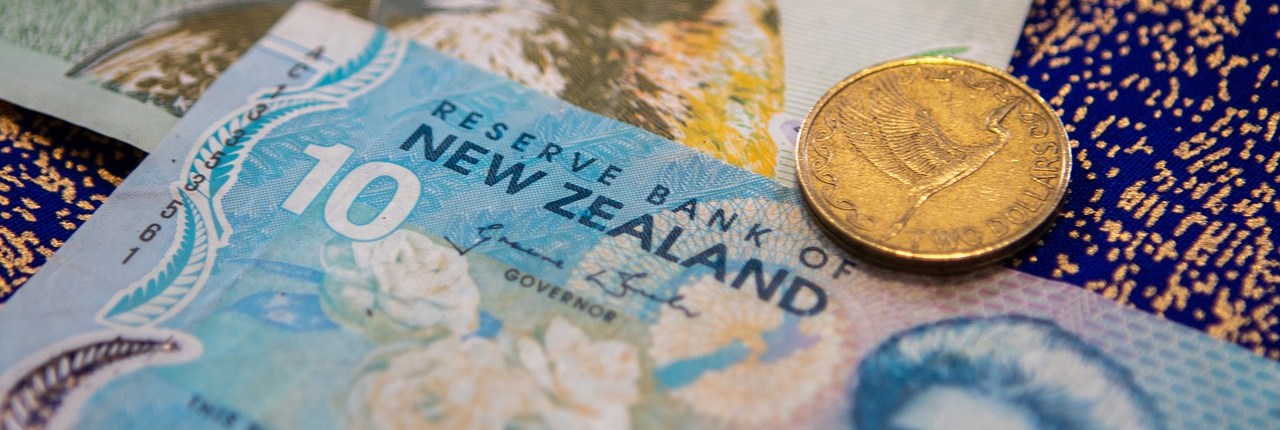 A close-up of a New Zealand coin and banknotes