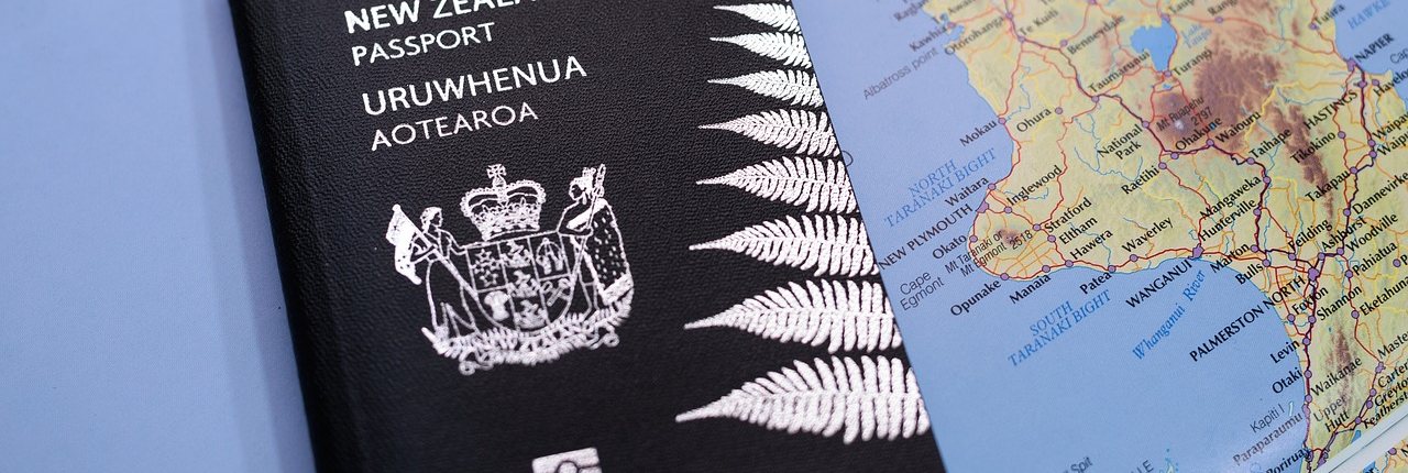 A New Zealand passport on top of a map of New Zealand